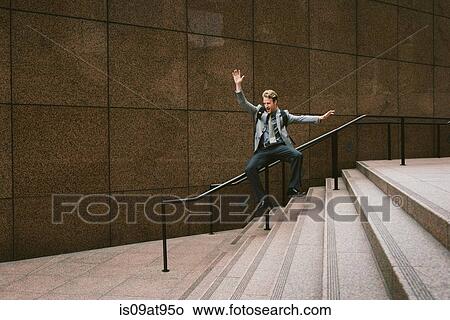 Businessman sliding down city stair handrail View Large Photo Image Picture - Businessman sliding down city stair handrail. Fotosearch