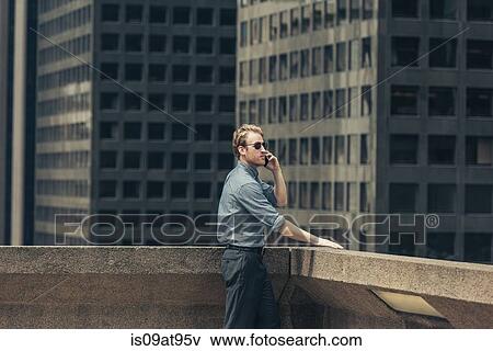 Businessman talking on smartphone from rooftop, Los Angeles, USA View Large Photo Image Stock Photo - Businessman talking on smartphone from rooftop, Los Angeles, USA. Fotosearch