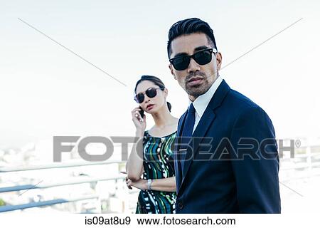 Businessman with businesswoman using smartphone on roof terrace, Los Angeles, California, USA View Large Photo Image Stock Photo - Businessman with businesswoman using smartphone on roof terrace, Los Angeles, California, USA. Fotosearch