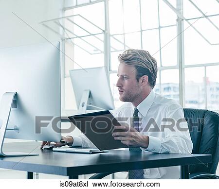 Businessman working at desk View Large Photo Image Stock Image - Businessman working at desk. Fotosearch