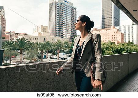 Stock Image - Businesswoman looking out from walkway, Los Angeles, USA. Fotosearch