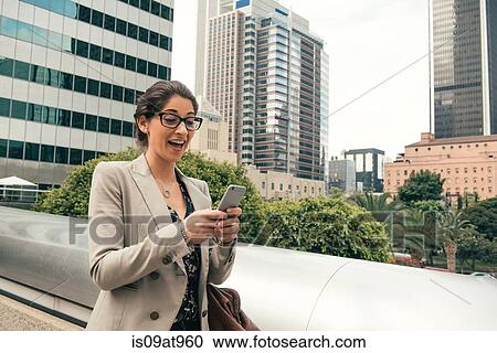 Businesswoman reading smartphone texts from footbridge, Los Angeles, USA View Large Photo Image Stock Image - Businesswoman reading smartphone texts from footbridge, Los Angeles, USA. Fotosearch