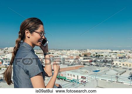Businesswoman speaking on smartphone on roof terrace, Los Angeles, California, USA View Large Photo Image Stock Image - Businesswoman speaking on smartphone on roof terrace, Los Angeles, California, USA. Fotosearch