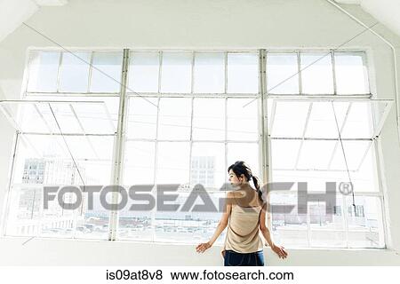 Businesswoman standing by office window View Large Photo Image Stock Photo - Businesswoman standing by office window. Fotosearch
