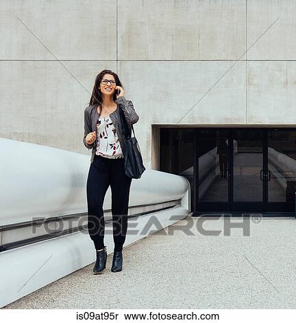 Businesswoman talking on smartphone on walkway View Large Photo Image Stock Photography - Businesswoman talking on smartphone on walkway. Fotosearch