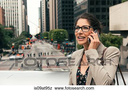 Stock Photo - Businesswoman talking on smartphone from footbridge, Los Angeles, USA. Fotosearch