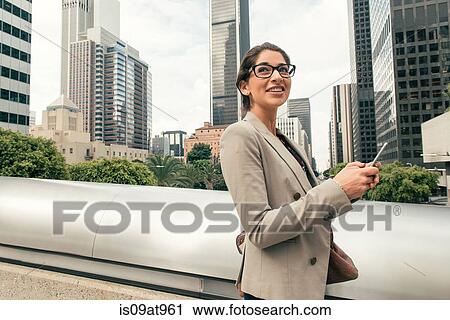 Businesswoman texting on smartphone from footbridge, Los Angeles, USA View Large Photo Image Stock Image - Businesswoman texting on smartphone from footbridge, Los Angeles, USA. Fotosearch
