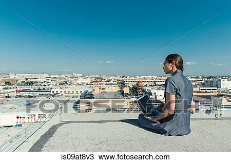 Businesswoman using laptop on roof terrace, Los Angeles, California, USA View Large Photo Image Stock Image - Businesswoman using laptop on roof terrace, Los Angeles, California, USA. Fotosearch