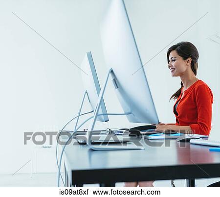 Businesswoman working at desk View Large Photo Image Stock Image - Businesswoman working at desk. Fotosearch