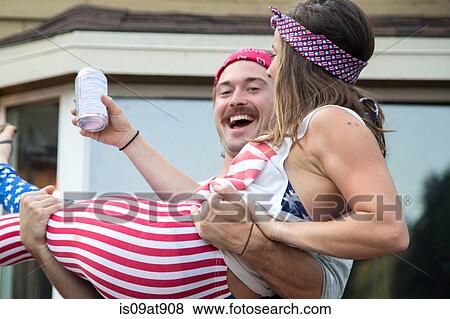 Couple wearing American flag costume celebrating Independence Day, USA View Large Photo Image Stock Photo - Couple wearing American flag costume celebrating Independence Day, USA. Fotosearch