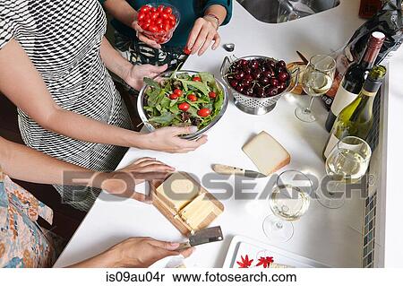 Cropped overhead view of female friends preparing lunch in kitchen View Large Photo Image Stock Photography - Cropped overhead view of female friends preparing lunch in kitchen. Fotosearch
