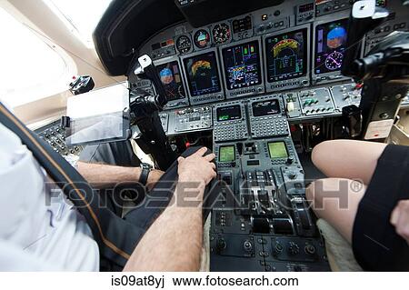 Cropped shot of male and female pilots knees in cockpit of private jet View Large Photo Image Stock Image - Cropped shot of male and female pilots knees in cockpit of private jet. Fotosearch