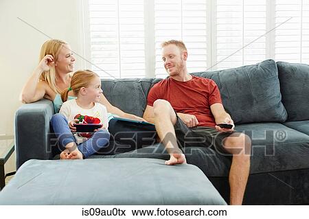 Family chatting and using smartphone on sofa in living room View Large Photo Image Stock Photo - Family chatting and using smartphone on sofa in living room. Fotosearch