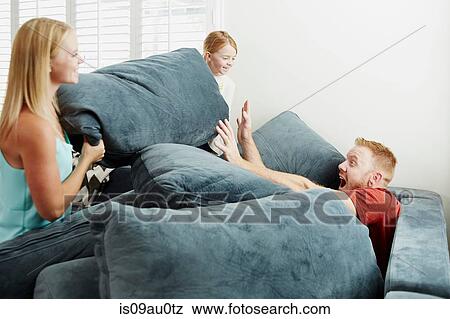Family playing on pile of cushions in living room View Large Photo Image Stock Photo - Family playing on pile of cushions in living room. Fotosearch