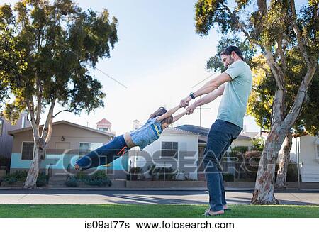 Father swinging son around, outdoors View Large Photo Image Stock Photograph - Father swinging son around, outdoors. Fotosearch