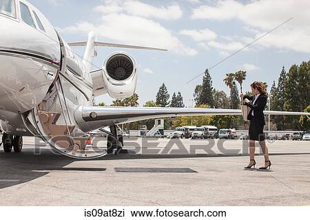 Female businesswoman preparing to board private jet at airport View Large Photo Image Stock Image - Female businesswoman preparing to board private jet at airport. Fotosearch