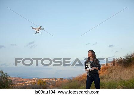 Female commercial operator flying drone looking up smiling, Santa Clarita, California, USA View Large Photo Image Picture - Female commercial operator flying drone looking up smiling, Santa Clarita, California, USA. Fotosearch