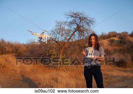 Female commercial operator on scrubland flying drone, looking down, Santa Clarita, California, USA View Large Photo Image Stock Image - Female commercial operator on scrubland flying drone, looking down, Santa Clarita, California, USA. Fotosearch