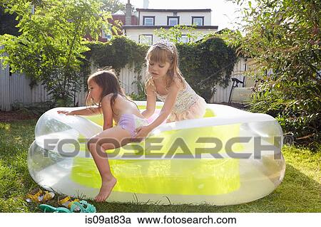 Girl helping friend out of inflatable pool View Large Photo Image Stock Image - Girl helping friend out of inflatable pool. Fotosearch