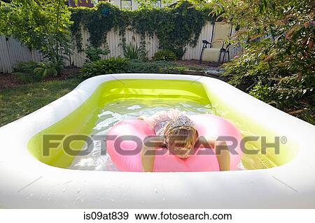 Girl lying on inflatable floating in pool View Large Photo Image Stock Photo - Girl lying on inflatable floating in pool. Fotosearch