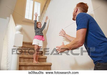 Girl preparing to jump into father's arms on staircase at home View Large Photo Image Stock Photograph - Girl preparing to jump into father's arms on staircase at home. Fotosearch