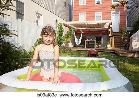 Stock Image - Girl sitting on inflatable floating in pool. Fotosearch