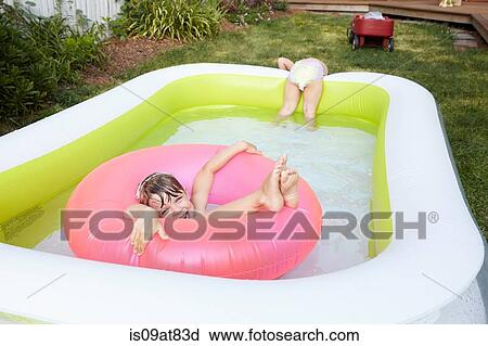 Stock Image - Girls having fun in inflatable pool. Fotosearch