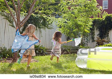 Picture - Girls in butterfly costumes playing in garden. Fotosearch
