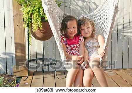 Girls sitting in hammock on porch View Large Photo Image Stock Image - Girls sitting in hammock on porch. Fotosearch
