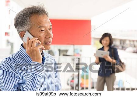 Head and shoulders of mature man talking on smartphone looking away View Large Photo Image Stock Photography - Head and shoulders of mature man talking on smartphone looking away. Fotosearch