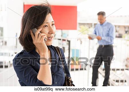 Head and shoulders of mature woman talking on smartphone looking away View Large Photo Image Stock Photography - Head and shoulders of mature woman talking on smartphone looking away. Fotosearch