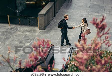 High angle view of businessman and woman shaking hands in city View Large Photo Image Picture - High angle view of businessman and woman shaking hands in city. Fotosearch