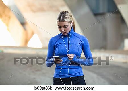 Jogger selecting music on smartphone View Large Photo Image Stock Image - Jogger selecting music on smartphone. Fotosearch