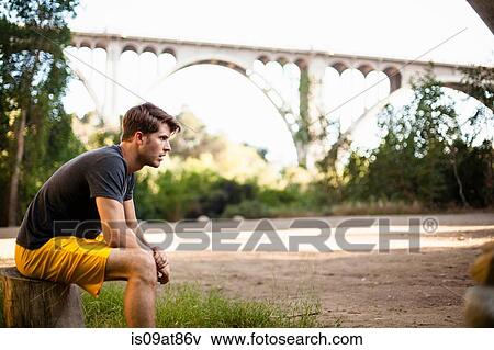 Stock Photo - Jogger taking break, arch bridge in background, Arroyo Seco Park, Pasadena, California, USA. Fotosearch