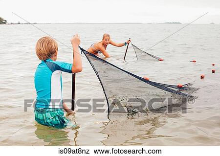 Kids in water using fishing net, Sanibel Island, Pine Island Sound, Florida, USA View Large Photo Image Stock Photo - Kids in water using fishing net, Sanibel Island, Pine Island Sound, Florida, USA. Fotosearch