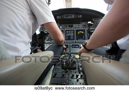 Male and female pilots in cockpit of private jet View Large Photo Image Stock Image - Male and female pilots in cockpit of private jet. Fotosearch