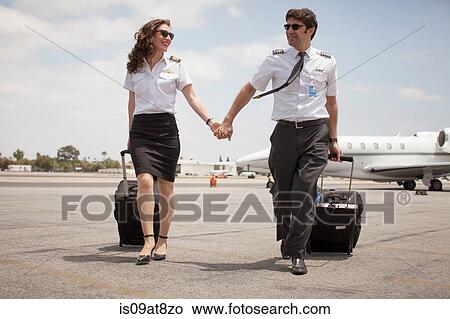 Male and female private jet pilots holding hands at airport View Large Photo Image Picture - Male and female private jet pilots holding hands at airport. Fotosearch