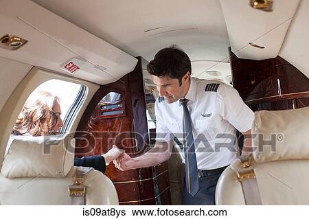 Male pilot helping female client board private jet View Large Photo Image Stock Photograph - Male pilot helping female client board private jet. Fotosearch