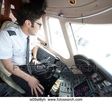 Male pilot looking through cockpit window of private jet View Large Photo Image Stock Image - Male pilot looking through cockpit window of private jet. Fotosearch