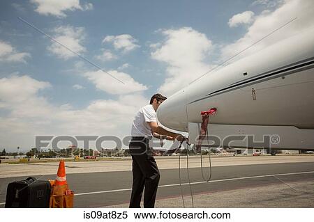 Male private jet pilot checking plane at airport View Large Photo Image Stock Photography - Male private jet pilot checking plane at airport. Fotosearch