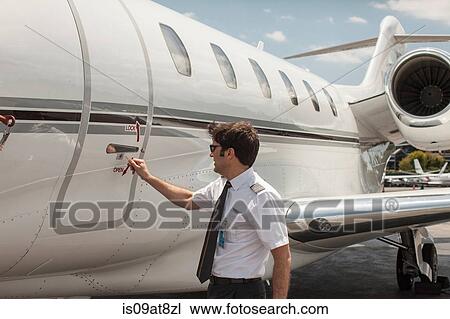Male private jet pilot locking plane door at airport View Large Photo Image Stock Image - Male private jet pilot locking plane door at airport. Fotosearch
