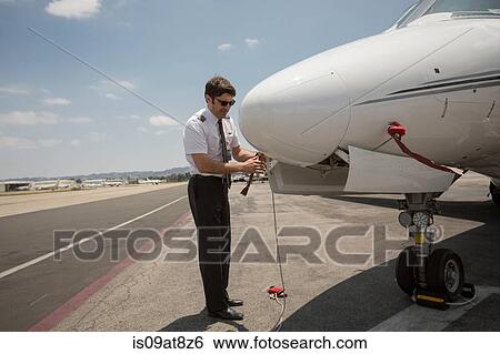 Male private jet pilot preparing plane at airport View Large Photo Image Stock Photograph - Male private jet pilot preparing plane at airport. Fotosearch