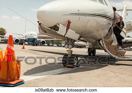 Male private jet pilots boarding plane at airport View Large Photo Image Stock Image - Male private jet pilots boarding plane at airport. Fotosearch
