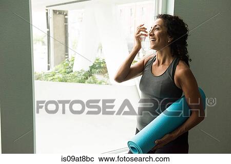 Mature woman holding yoga mat drinking water View Large Photo Image Stock Image - Mature woman holding yoga mat drinking water. Fotosearch