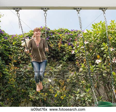 Mature woman swinging on garden swing View Large Photo Image Stock Photo - Mature woman swinging on garden swing. Fotosearch