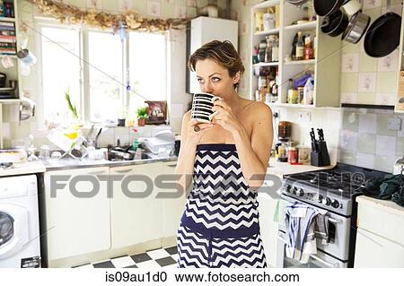 Mid adult woman drinking coffee in kitchen View Large Photo Image Stock Image - Mid adult woman drinking coffee in kitchen. Fotosearch