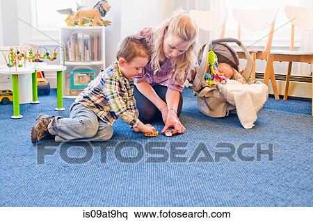Stock Photography - Mother and children playing together in waiting room. Fotosearch