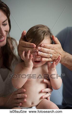 Mother and father playing peek a boo with baby boy View Large Photo Image Stock Photo - Mother and father playing peek a boo with baby boy. Fotosearch