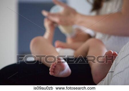 Mother feeding barefoot baby boy, focus on foreground View Large Photo Image Stock Image - Mother feeding barefoot baby boy, focus on foreground. Fotosearch