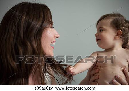 Mother holding bare chested baby boy, face to face smiling View Large Photo Image Stock Photo - Mother holding bare chested baby boy, face to face smiling. Fotosearch
